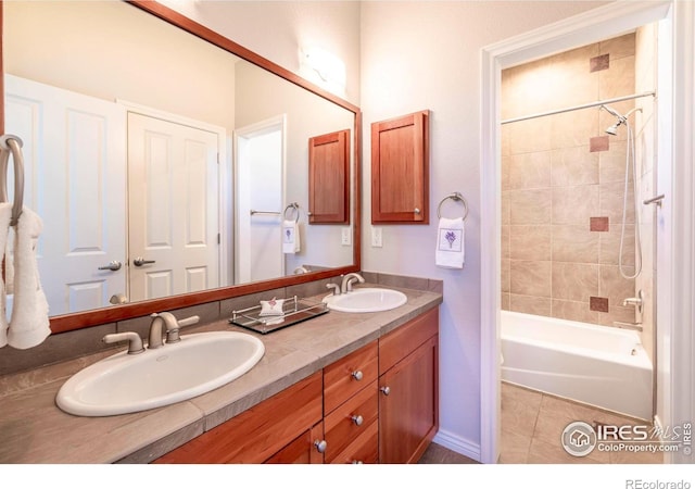 bathroom with tile patterned flooring, vanity, and tiled shower / bath