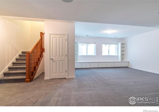 unfurnished room featuring dark colored carpet