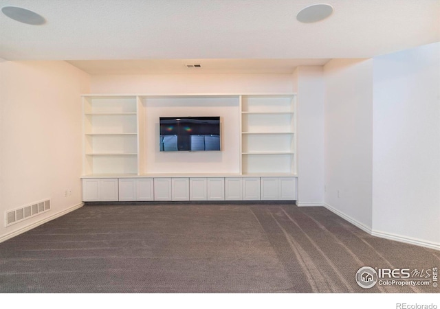 unfurnished living room with dark carpet