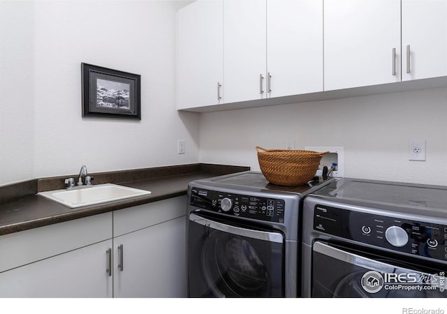 washroom featuring cabinets, washer and clothes dryer, and sink