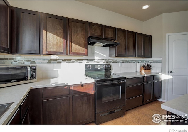 kitchen with black range with electric stovetop, decorative backsplash, dark brown cabinetry, and light wood-type flooring