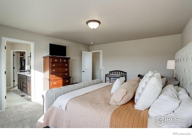 bedroom with connected bathroom and light colored carpet