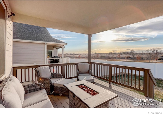 deck at dusk featuring a fire pit