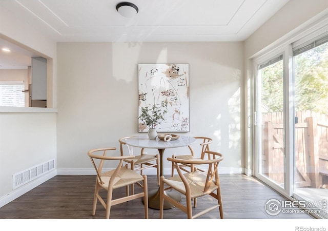 dining space featuring wood finished floors, visible vents, and baseboards
