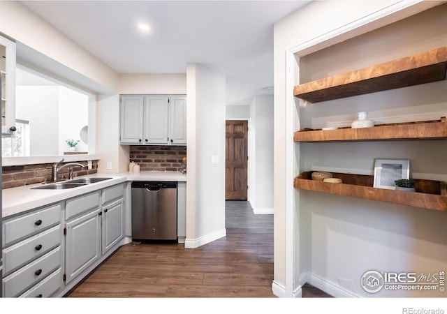 kitchen with decorative backsplash, dishwasher, open shelves, and a sink