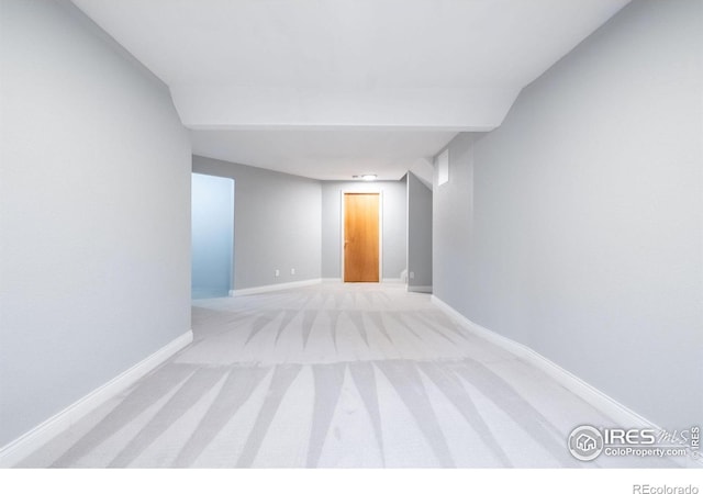 unfurnished room featuring baseboards and light colored carpet