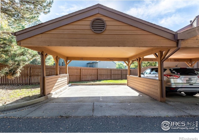 view of parking featuring a carport and fence