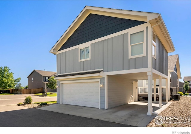 view of front of property featuring central AC unit and a garage