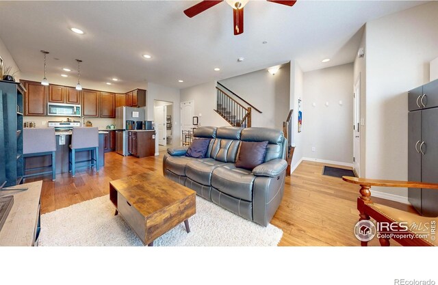 living room featuring ceiling fan and light wood-type flooring