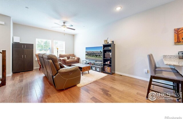 living room with ceiling fan and light hardwood / wood-style floors