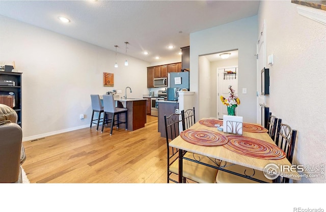 dining area featuring sink and light wood-type flooring