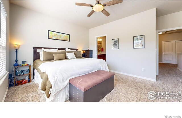 bedroom with multiple windows, ensuite bathroom, light colored carpet, and ceiling fan