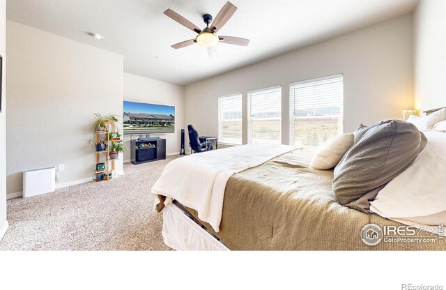 carpeted bedroom featuring a fireplace and ceiling fan