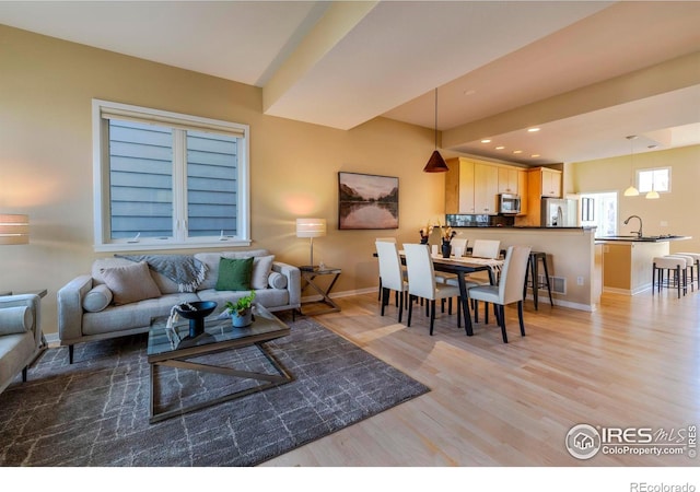 living area featuring light wood-style floors, recessed lighting, and baseboards