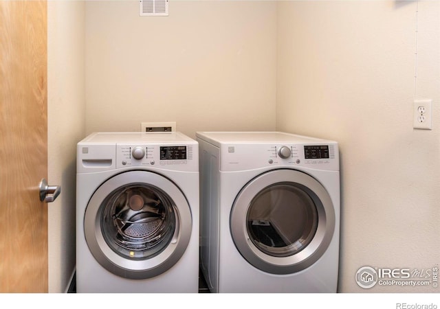 laundry room featuring laundry area, visible vents, and separate washer and dryer