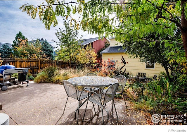 view of patio with outdoor dining space and fence