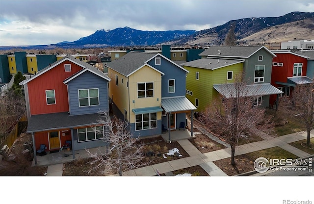 traditional-style house featuring a porch, a residential view, a mountain view, and a patio