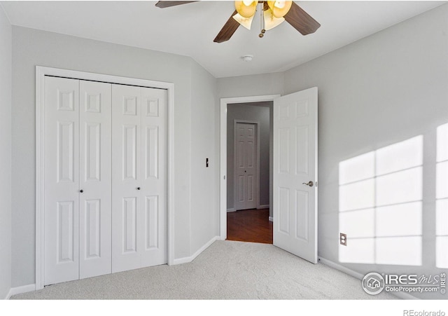 unfurnished bedroom featuring light carpet, a closet, and ceiling fan