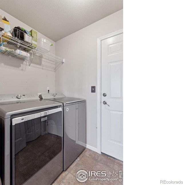 laundry area featuring light tile patterned flooring and independent washer and dryer