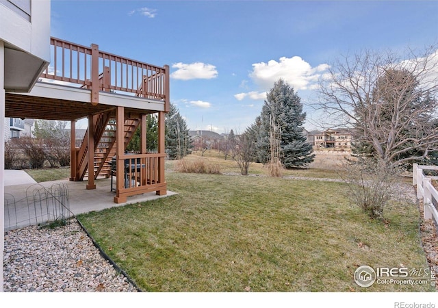 view of yard with a wooden deck and a patio