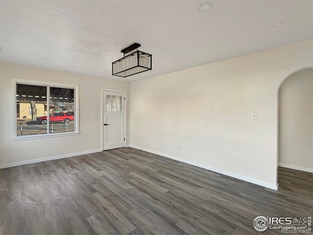 empty room with dark hardwood / wood-style flooring