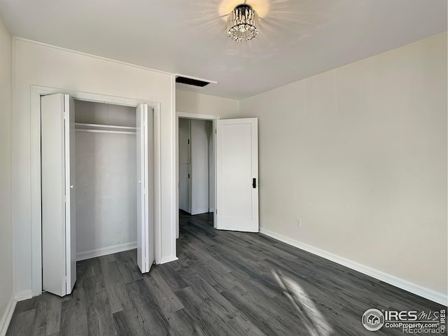 unfurnished bedroom with dark hardwood / wood-style flooring and a closet