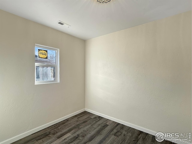 unfurnished room featuring dark wood-type flooring