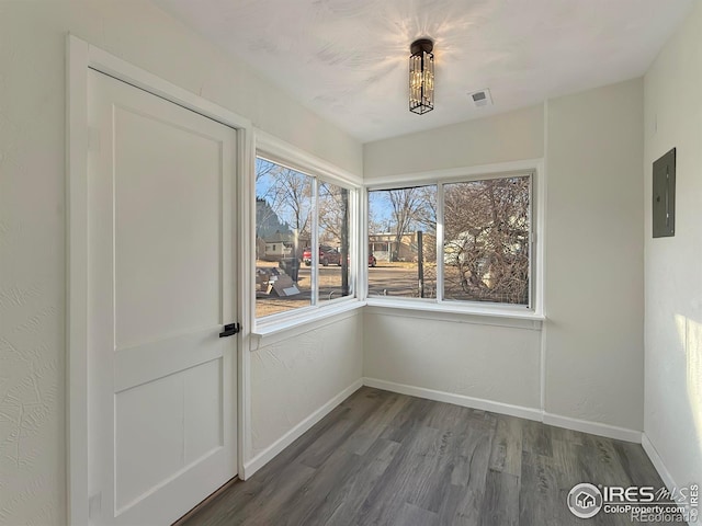 unfurnished dining area featuring hardwood / wood-style flooring and electric panel