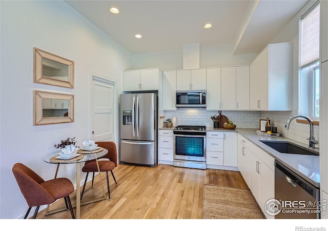 1998 Foxtail Ln Unit B, Lafayette, CO 80026 - kitchen with appliances with stainless steel finishes, a sink, light wood finished floors, backsplash, and recessed lighting