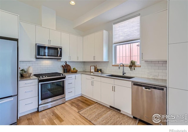 1998 Foxtail Ln Unit B, Lafayette, CO 80026 - kitchen with stainless steel appliances, a sink, light wood-style flooring, white cabinets, and recessed lighting