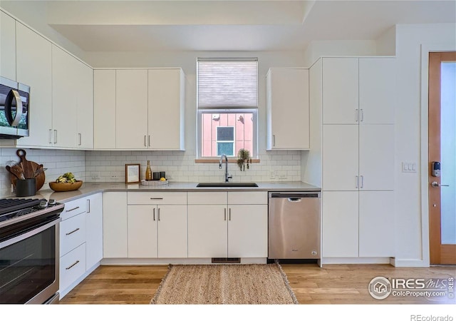 1998 Foxtail Ln Unit B, Lafayette, CO 80026 - kitchen featuring stainless steel appliances, a sink, light wood-style floors, and tasteful backsplash