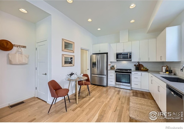 1998 Foxtail Ln Unit B, Lafayette, CO 80026 - kitchen with appliances with stainless steel finishes, a sink, light wood-type flooring, tasteful backsplash, and recessed lighting