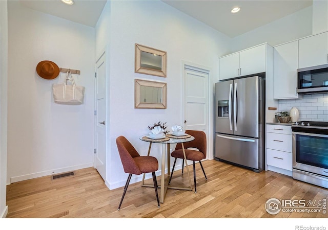 1998 Foxtail Ln Unit B, Lafayette, CO 80026 - kitchen featuring stainless steel appliances, light wood-style floors, backsplash, white cabinetry, and recessed lighting