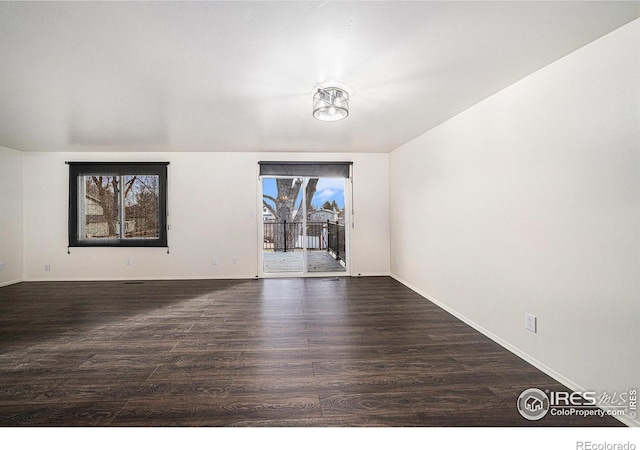 unfurnished room with dark wood-type flooring