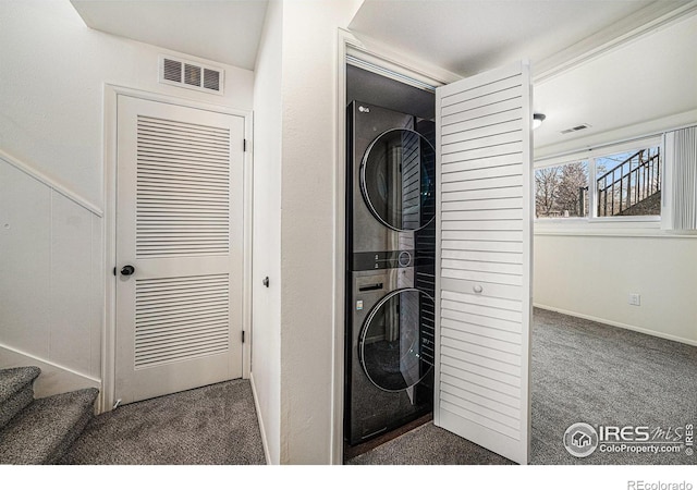 washroom featuring stacked washer and dryer and dark carpet