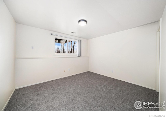 empty room featuring dark colored carpet