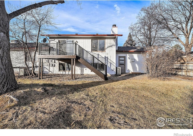 rear view of property with central AC, a deck, and a lawn