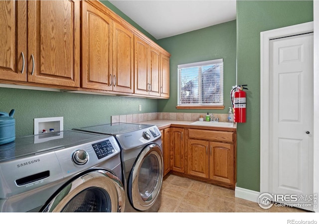 laundry room featuring cabinets, washing machine and clothes dryer, and sink