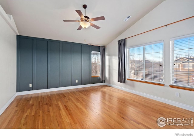 spare room featuring vaulted ceiling, ceiling fan, and light wood-type flooring