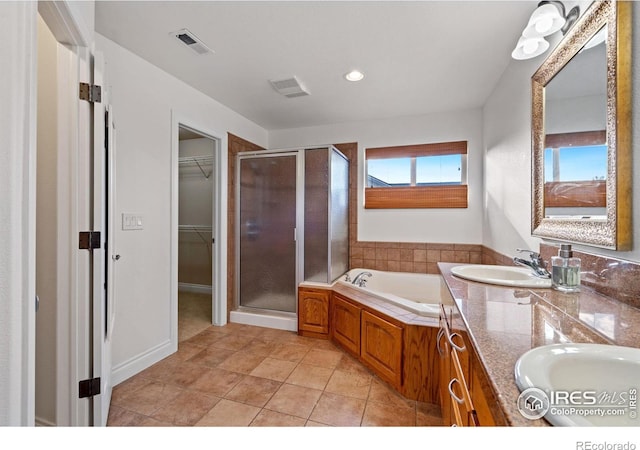 bathroom with independent shower and bath, vanity, and tile patterned flooring