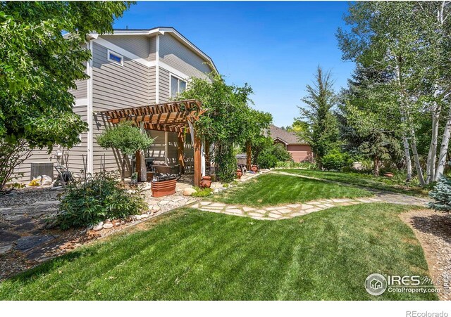 view of yard with central AC and a pergola