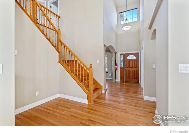 foyer featuring a towering ceiling and light wood-type flooring