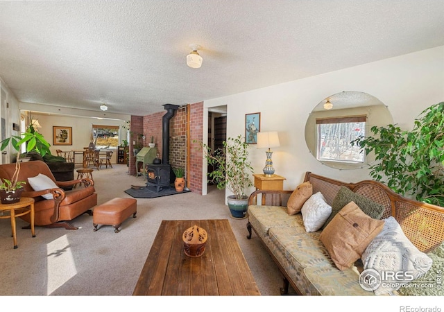 carpeted living room with a wood stove and a textured ceiling