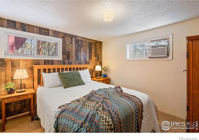 bedroom with carpet flooring, a textured ceiling, and wooden walls