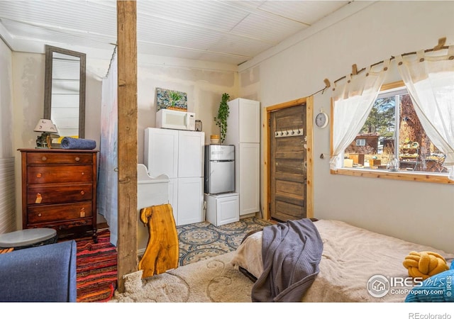 bedroom with stainless steel refrigerator