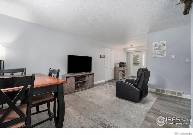 living room with wood-type flooring and a textured ceiling