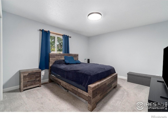 bedroom featuring light carpet and a textured ceiling