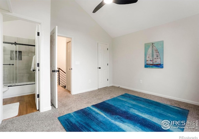 carpeted bedroom featuring lofted ceiling, ceiling fan, baseboards, and ensuite bathroom