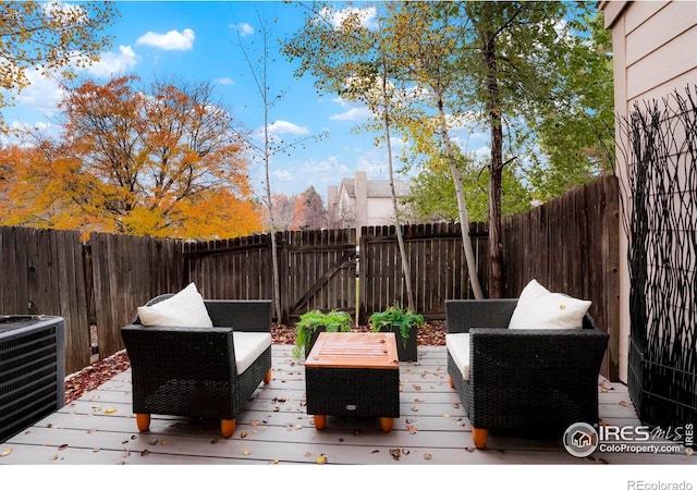 wooden terrace with cooling unit, a fenced backyard, and outdoor lounge area