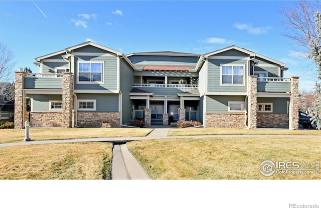 view of front of property featuring a front yard and a balcony